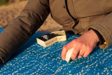 Surfer waxing a board with Rad Wax Base Coat