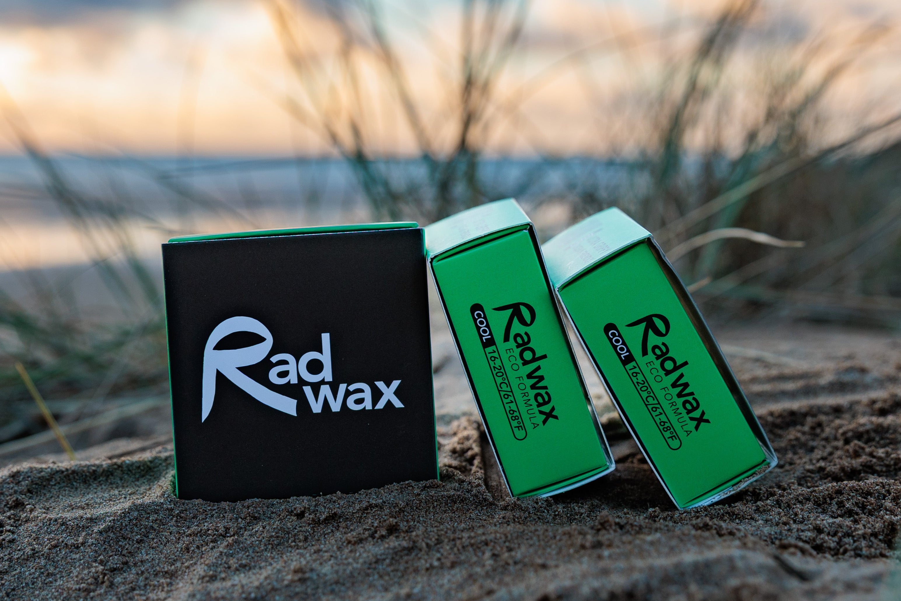 Rad Wax Cool Eco Surf Wax on sand with ocean and sky in the background