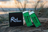Rad Wax Cool Eco Surf Wax on sand with ocean and sky in the background