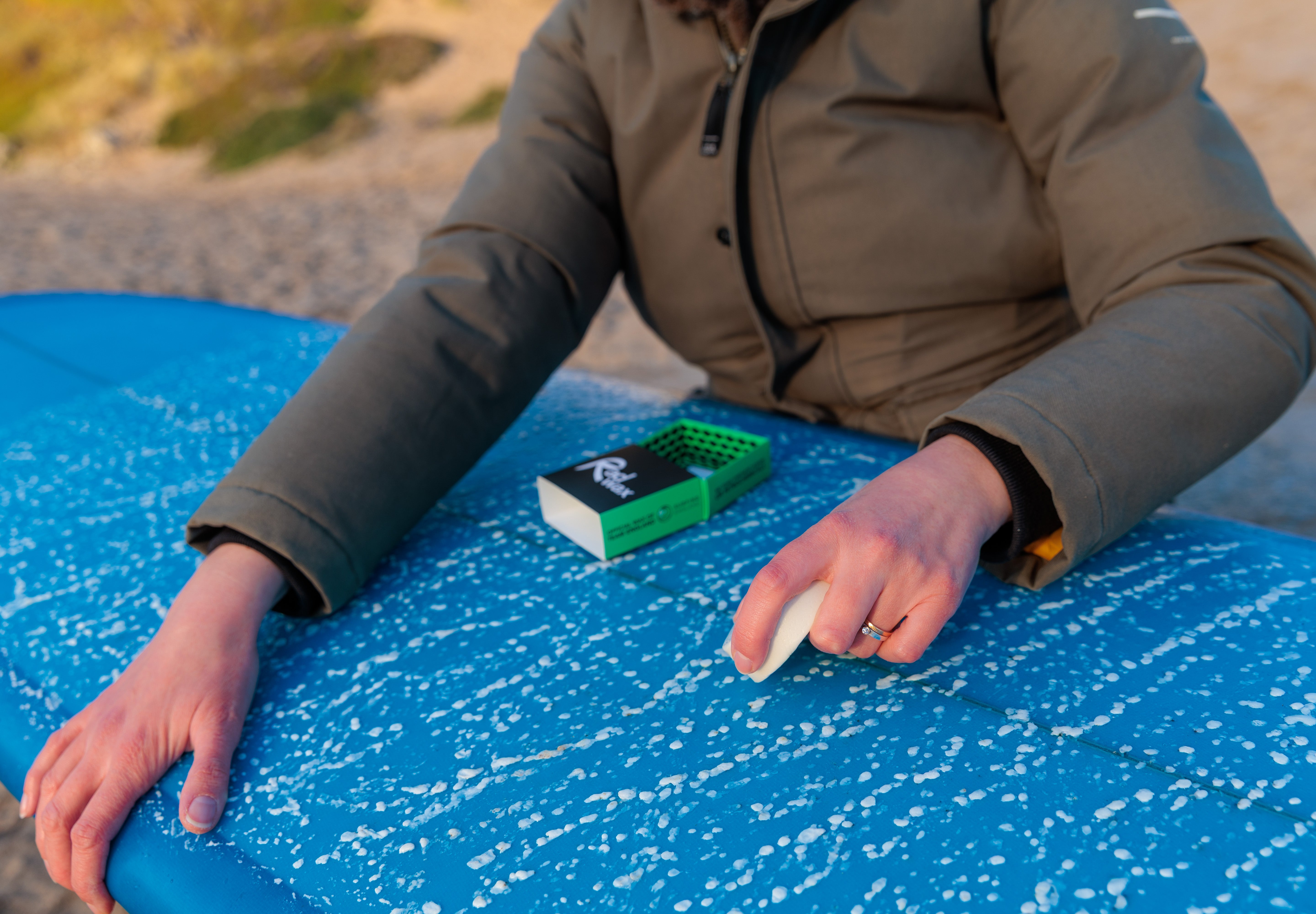 Surfer waxing a board with Rad Wax Cool Eco Surf Wax