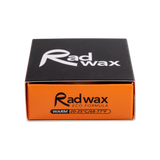 Rad Wax Warm Water eco surfboard wax. Packaging with black and orange design on a white background